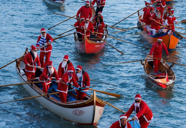 People dressed as Santa Claus row during a Christmas regatta in Venice, Italy December 17, 2017. REUTERS/Manuel Silvestri