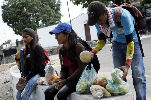 Marlon Carrillo (R) organizes the fruits bought in Venezuela as he waits for customers in Cucuta, Colombia December 15, 2017. Picture taken December 15, 2017. REUTERS/Carlos Eduardo Ramirez