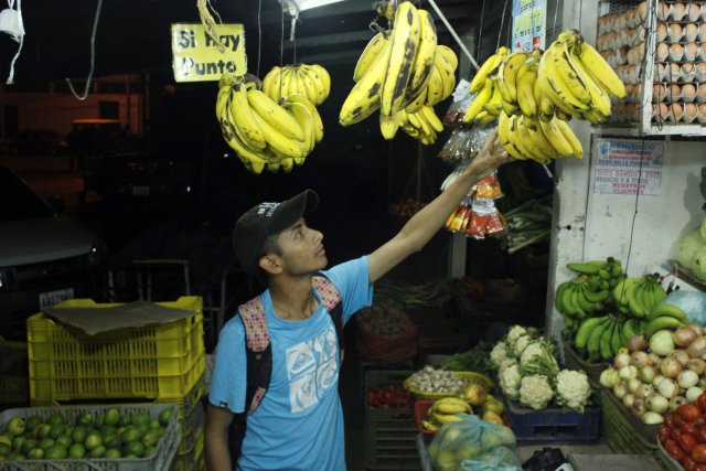 Marlon Carrillo buys fruits to resell them in Colombia, at a market in Rubio, Venezuela December 15, 2017. Picture taken December 15, 2017. REUTERS/Carlos Eduardo Ramirez