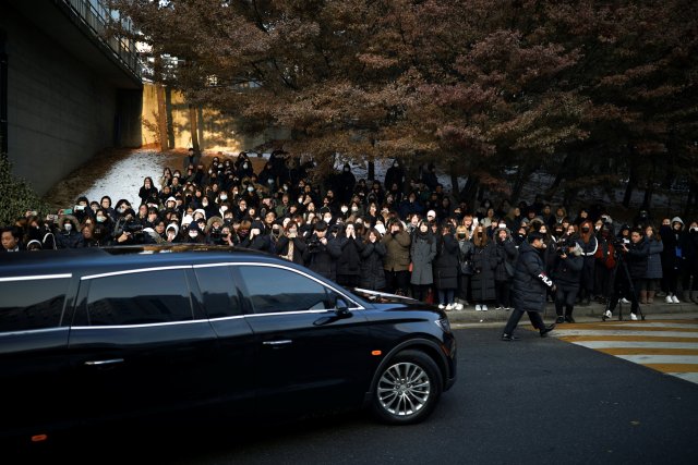 A hearse carrying the coffin of Kim Jong-hyun, lead singer of top South Korean boy band SHINee, drives past his fans at a hospital in Seoul, South Korea, December 21, 2017. REUTERS/Kim Hong-Ji