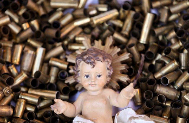 A statue of the baby Jesus on a bed of bullet shells is seen in a Nativity scene outside the Basilica of St Francis in Assisi, Italy, December 21, 2017. The 445 shells represent the number of priests, nuns, monks and religious teachers killed for their faith since 2000. Picture taken December 21, 2017.  REUTERS/Alessandro Bianchi