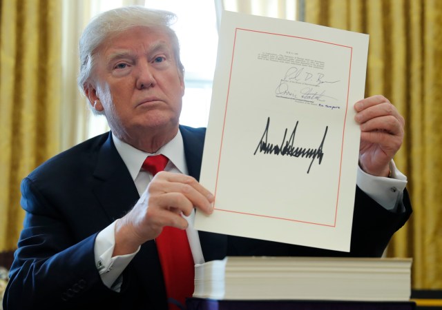 U.S. President Donald Trump displays his signature after signing the $1.5 trillion tax overhaul plan in the Oval Office of the White House in Washington, U.S., December 22, 2017. REUTERS/Jonathan Ernst