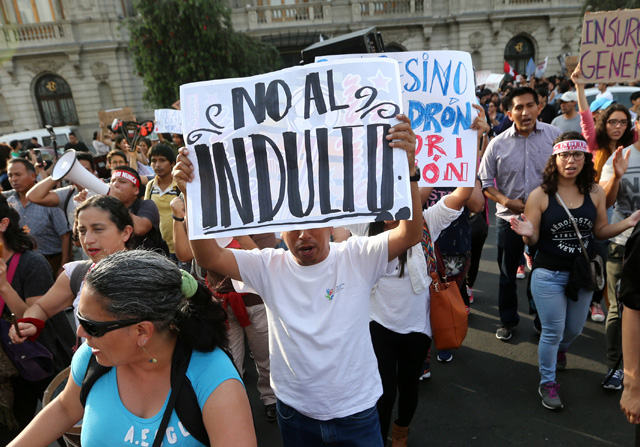 Manifestantes levantan una pancarta durante una manifestación en Lima después de que el presidente peruano Pedro Pablo Kuczynski perdonó al exmandatario Alberto Fujimori, Perú, 25 de diciembre de 2017. REUTERS/Mariana Bazo