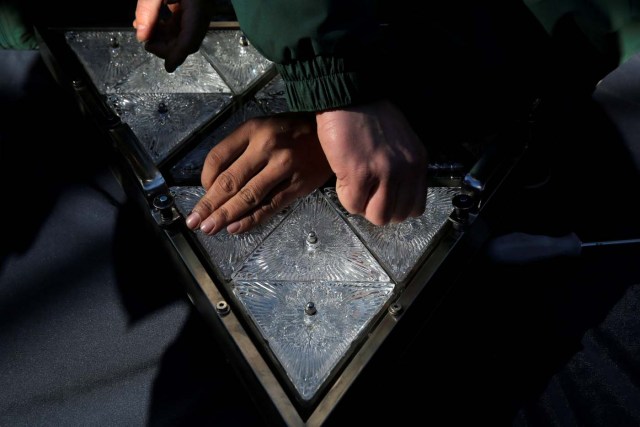 Workers prepare a panel of Waterford Crystal triangles before attaching it to the Times Square New Year's Eve Ball on the roof of One Times Square in Manhattan, New York, U.S., December 27, 2017. REUTERS/Andrew Kelly