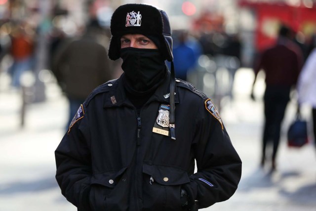 A New York Police Department (NYPD) officer bundles up against the cold temperature as he walks in Times Square in Manhattan, New York, U.S., December 28, 2017. REUTERS/Amr Alfiky