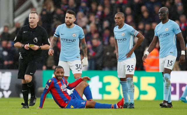Soccer Football - Premier League - Crystal Palace vs Manchester City - Selhurst Park, London, Britain - December 31, 2017   Crystal Palace's Jason Puncheon lies injured as referee Jonathan Moss, Nicolas Otamendi, Fernandinho and Eliaquim Mangala look on   REUTERS/David Klein    EDITORIAL USE ONLY. No use with unauthorized audio, video, data, fixture lists, club/league logos or "live" services. Online in-match use limited to 75 images, no video emulation. No use in betting, games or single club/league/player publications.  Please contact your account representative for further details.