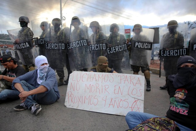TGP07. TEGUCIGALPA (HONDURAS) 15/12/2017.- Miembros de la policía y del ejército de Honduras rodean a un grupo de manifestantes hoy, viernes 15 de diciembre de 2017, en Tegucigalpa (Honduras). Cientos de manifestantes bloquearon hoy importantes carreteras en las principales ciudades de Honduras en protesta por el presunto "fraude" en los comicios del 26 de noviembre contra el candidato de la Alianza de Oposición contra la Dictadura, Salvador Nasralla. EFE/Gustavo Amador