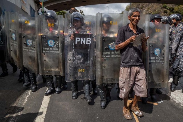 CAR27. CARACAS (VENEZUELA), 28/12/2018.- Un hombre protesta frente a miembros de la Policía Nacional Bolivariana (PNB) hoy, jueves 28 de diciembre del 2017, en Caracas (Venezuela). Las protestas por la escasez, la carestía de alimentos y la falta de gas doméstico y agua continuaron hoy en Caracas y otras ciudades del país, según pudo constatar Efe y de acuerdo con información de medios locales. EFE/MIGUEL GUTIÉRREZ