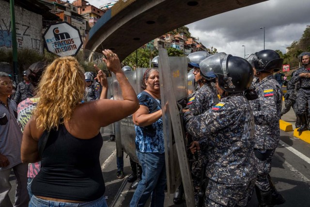 CAR24. CARACAS (VENEZUELA), 28/12/2018.- Un grupo de personas protesta frente a miembros de la Policía Nacional Bolivariana (PNB) hoy, jueves 28 de diciembre del 2017, en Caracas (Venezuela). Las protestas por la escasez, la carestía de alimentos y la falta de gas doméstico y agua continuaron hoy en Caracas y otras ciudades del país, según pudo constatar Efe y de acuerdo con información de medios locales. EFE/MIGUEL GUTIÉRREZ