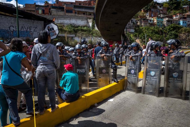 CAR22. CARACAS (VENEZUELA), 28/12/2018.- Un grupo de personas protesta frente a miembros de la Policía Nacional Bolivariana (PNB) hoy, jueves 28 de diciembre del 2017, en Caracas (Venezuela). Las protestas por la escasez, la carestía de alimentos y la falta de gas doméstico y agua continuaron hoy en Caracas y otras ciudades del país, según pudo constatar Efe y de acuerdo con información de medios locales. EFE/MIGUEL GUTIÉRREZ