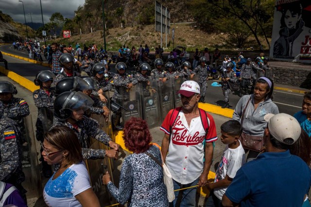 CAR21. CARACAS (VENEZUELA), 28/12/2018.- Un grupo de personas protesta frente a miembros de la Policía Nacional Bolivariana (PNB) hoy, jueves 28 de diciembre del 2017, en Caracas (Venezuela). Las protestas por la escasez, la carestía de alimentos y la falta de gas doméstico y agua continuaron hoy en Caracas y otras ciudades del país, según pudo constatar Efe y de acuerdo con información de medios locales. EFE/MIGUEL GUTIÉRREZ