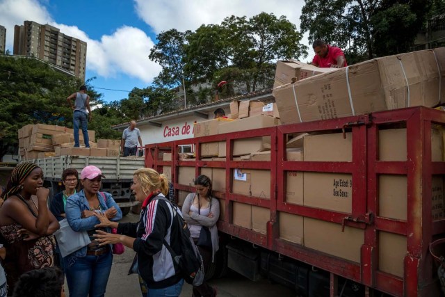 CAR110. CARACAS (VENEZUELA), 28/12/2018.- Un grupo de personas adeptas al oficialismo saca juguetes de una Casa de Asambleas del Poder Popular para repartirlos en el sector La Vega, después de que este recinto fuese asediado por manifestantes en horas de la madrugada hoy, jueves 28 de diciembre del 2017, en Caracas (Venezuela). Durante la madrugada de este jueves se registraron en varios puntos de Venezuela protestas por la escasez de alimentos para completar el menú navideño, gas y agua, informaron hoy medios locales. EFE/MIGUEL GUTIÉRREZ