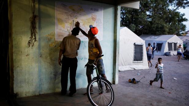 Venezolanos observan un mapa en un gimnasio de Boa Vista convertido en refugio - ABC