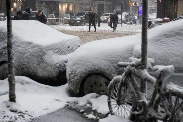 People make their way during a winter storm in New York on January 4, 2018. A giant winter "bomb cyclone" walloped the US East Coast on Thursday with freezing cold and heavy snow, forcing thousands of flight cancellations and widespread school closures -- and even prompting the US Senate to cancel votes for the rest of the week. / AFP PHOTO / Jewel SAMAD
