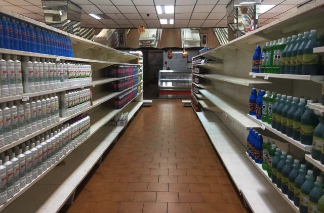View of partially empty supermarket shelves in Caracas on January 6, 2018.  Venezuela's government forced more that 200 establishments to lower prices in the middle of a hyperinflationary spiral. / AFP PHOTO / JUAN BARRETO