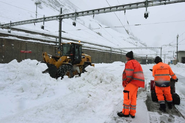 Workers attempt to clear snow from the railway tracks at the Zermatt train station after heavy snowfall trapped more than 13,000 tourists at Zermatt, which is one of Switzerland's most popular ski stations on January 09, 2018. The snow has blocked all roads and the train leading to the resort in the southern Swiss canton of Valais, which was also hit by some power outages. / AFP PHOTO / Mark Ralston