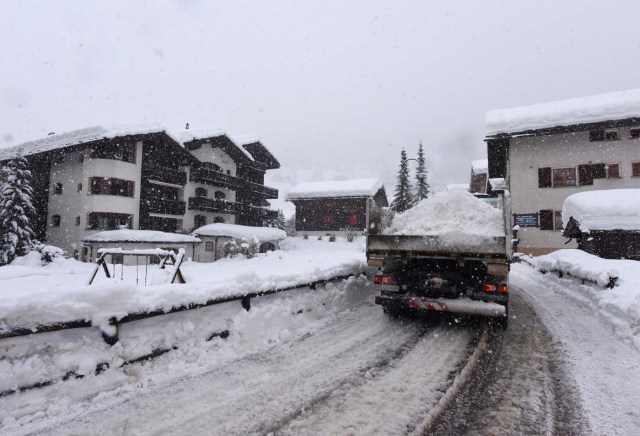 Workers remove snow beside the Zermatt train station after heavy snowfall and avalanches trapped more than 13,000 tourists at Zermatt, which is one of Switzerland's most popular ski stations on January 09, 2018. The snow has blocked all roads and the train leading to the resort in the southern Swiss canton of Valais, which was also hit by some power outages. / AFP PHOTO / Mark Ralston