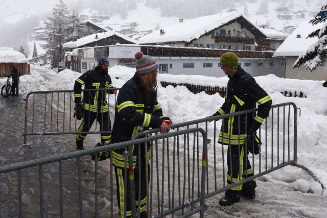 Emergency workers block a road beside the Zermatt train station after heavy snowfall and avalanches trapped more than 13,000 tourists at Zermatt, which is one of Switzerland's most popular ski stations on January 09, 2018. The snow has blocked all roads and the train leading to the resort in the southern Swiss canton of Valais, which was also hit by some power outages. / AFP PHOTO / Mark Ralston