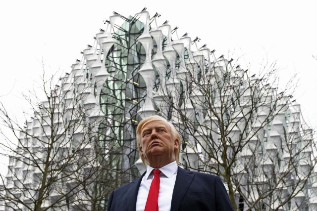 A Madame Tussauds wax figure of US President Donald Trump stands outside the new US Embassy in Embassy Gardens in south-west London on January 12, 2018. US President Donald Trump said today he no longer plans to attend the opening of the new US embassy in London. He announced the decision in a midnight tweet amid reports in Britain that a Trump visit would be met with protests. / AFP PHOTO / Daniel SORABJI