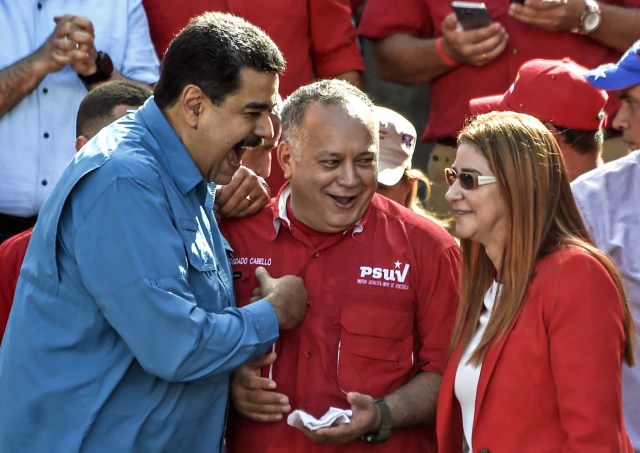 Venezuelan President Nicolas Maduro (L) talks member of the Constituent Assembly Diosdado Cabello (C) and First Lady Cilia Flores (R) greet supporters during a rally in Caracas on January 23, 2018. Venezuela's Maduro says he is ready to run for a second term. / AFP PHOTO / Juan BARRETO