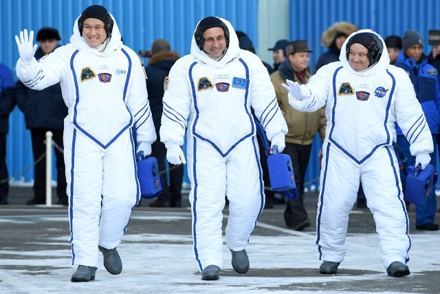 Los astronautas Anton Shkaplerov (Rusia, centro), Scott Tingle (EEUU, dcha) y Norishige Kanai (Japón) durante la ceremonia previa a su partida hacia la Estación Espacial Internacional en el cosmódromo de Baikonur, Kazajistán. 17 diciembre 2017. REUTERS/Kirill Kudryavtsev/Pool