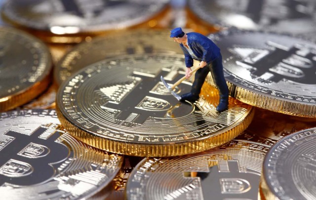 A small toy figure is seen on representations of the Bitcoin virtual currency in this illustration picture, December 26, 2017. REUTERS/Dado Ruvic/Illustration