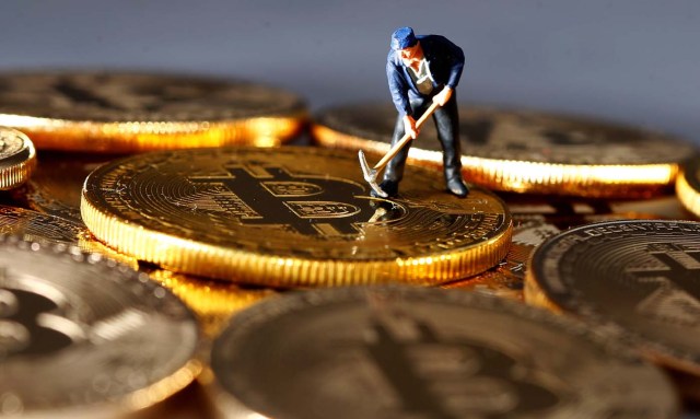 A small toy figure is seen on representations of the Bitcoin virtual currency in this illustration picture, December 26, 2017. REUTERS/Dado Ruvic/Illustration