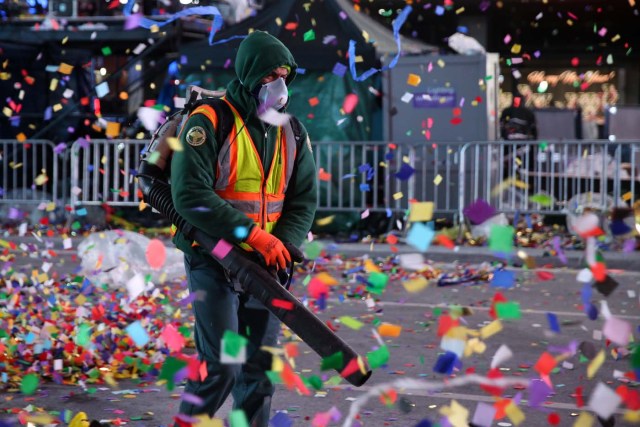 A New York City Department of Sanitation worker cleans the streets after the New Year celebrations in Times Square in Manhattan, New York, U.S., January 1, 2018. REUTERS/Amr Alfiky
