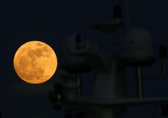A 'supermoon' full moon rises behind the antennae domes on a motor yacht in Pieta, Malta, January 1, 2018. REUTERS/Darrin Zammit Lupi