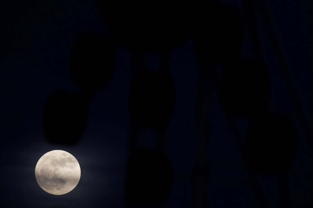 The 'supermoon' full moon is seen rising behind an advertising billboard in Ronda, southern Spain January 1, 2018. REUTERS/Jon Nazca