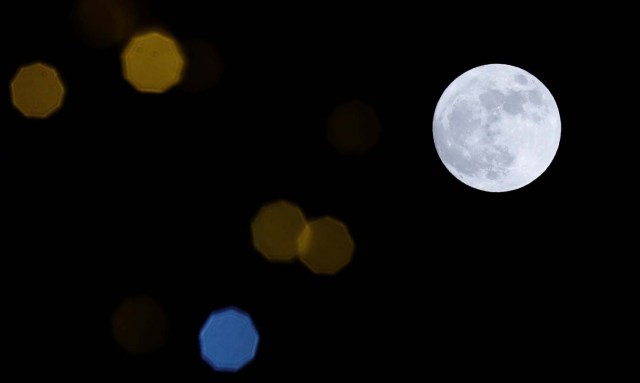 A 'supermoon' full moon is seen through Christmas lights in Harpenden, Britain, January 1, 2018. REUTERS/Peter Cziborra