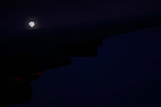 A 'supermoon' full moon can be seen in the distance over the wing of Air Force One as U.S. President Donald Trump returns to Washington at the conclusion on his holiday vacation, from Palm Beach International Airport in West Palm Beach, Florida, U.S. January 1, 2018. REUTERS/Jonathan Ernst