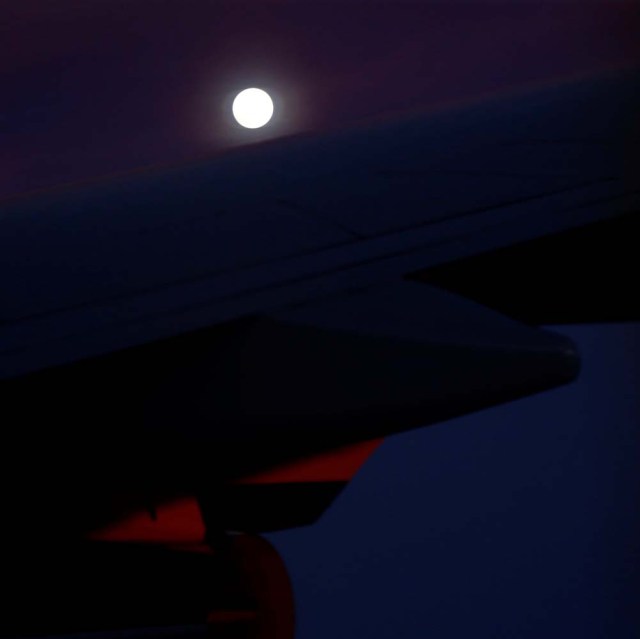 A 'supermoon' full moon can be seen in the distance over the wing of Air Force One as U.S. President Donald Trump returns to Washington at the conclusion on his holiday vacation, from Palm Beach International Airport in West Palm Beach, Florida, U.S. January 1, 2018. REUTERS/Jonathan Ernst