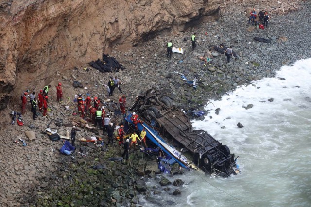 ATTENTION EDITORS - VISUALS COVERAGE OF SCENES OF DEATH AND INJURY Rescue workers work at the scene after a bus crashed with a truck and careened off a cliff along a sharply curving highway north of Lima, Peru, January 2, 2018. REUTERS/Guadalupe Pardo TEMPLATE OUT.