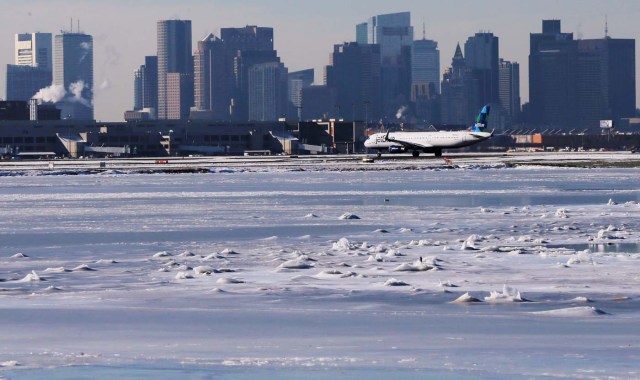 Ahead of an incoming winter snow storm, a Jet Blue flight waits to take off from Logan International Airport next to the frozen waters of the Atlantic Ocean harbour between Winthrop and Boston, Massachusetts, U.S., January 3, 2018. REUTERS/Brian Snyder
