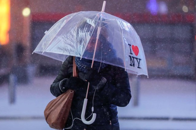 A woman walks in Times Square during a winter storm in Manhattan, New York, U.S. January 4, 2018. REUTERS/Jeenah Moon