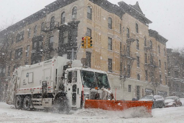 A garbage truck with a plow clears the street during a snowstorm in the Brooklyn borough of New York City, U.S., January 4, 2018. REUTERS/Brendan McDermid
