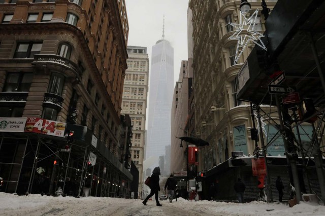 A pedestrian crosses the street in front of One World Trade as Storm Grayson in New York, U.S., January 4, 2018. REUTERS/Lucas Jackson