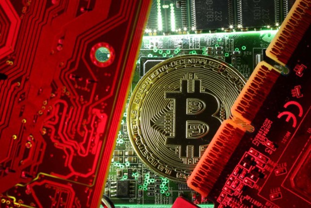Imagen de archivo de una moneda que representa la criptomoneda bitcoin entre unas placas madre de un ordenador en la foto ilustrativa tomada el 26 de octubre de 2017. REUTERS/Dado Ruvic