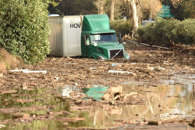 A semi-tractor trailer sits stuck in mud and flood waters on the highway after mudslides in Montecito, California, U.S. in this photo provided by the Santa Barbara County Fire Department, January 9, 2018. Picture taken January 9, 2018. Mike Eliason/Santa Barbara County Fire Department/Handout via REUTERS ATTENTION EDITORS - THIS IMAGE WAS PROVIDED BY A THIRD PARTY.