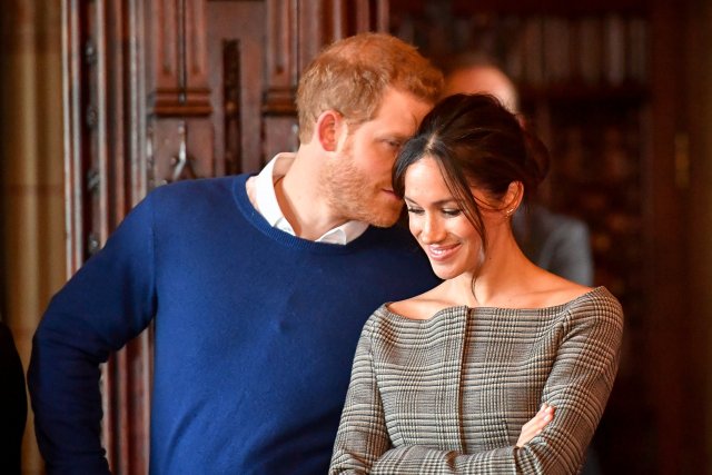 Britain's Prince Harry whispers to Meghan Markle as they watch a performance by a Welsh choir in the banqueting hall during a visit to Cardiff Castle in Cardiff, Britain, January 18, 2018. REUTERS/Ben Birchall/Pool