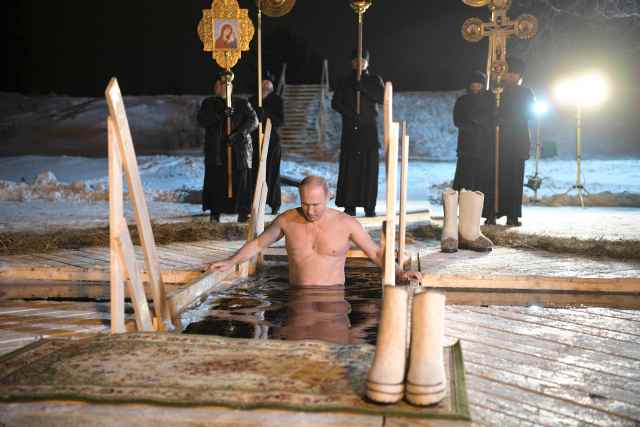 Russian President Vladimir Putin walks down into a hole in the ice before taking a dip in the freezing waters of Lake Seliger during Orthodox Epiphany celebrations in Tver region, Russia January 19, 2018. Sputnik/Alexei Druzhinin/Kremlin via REUTERS ATTENTION EDITORS - THIS IMAGE WAS PROVIDED BY A THIRD PARTY.