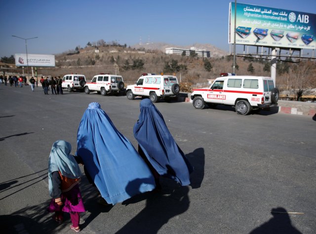 Afghan women and child walk by ambulances during an attack on the Intercontinental Hotel in Kabul, Afghanistan January 21, 2018. REUTERS/Mohammad Ismail