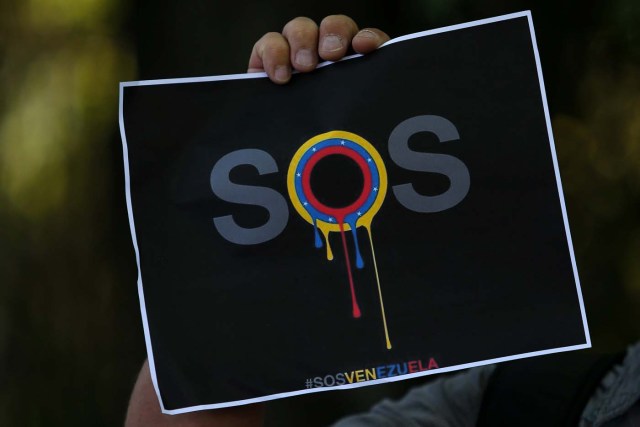 "SOS" is seen written with the colours of Venezuelan flag during a rally against Venezuela's government as members of Lima Group nations meet in Santiago, Chile January 23, 2018. REUTERS/Ivan Alvarado