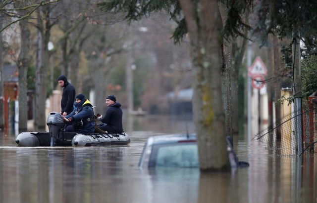 Paris police divers use a small boat to patrol a flooded street of a residential area in Villeneuve-Saint-Georges, near Paris, France January 25, 2018. REUTERS/Christian Hartmann