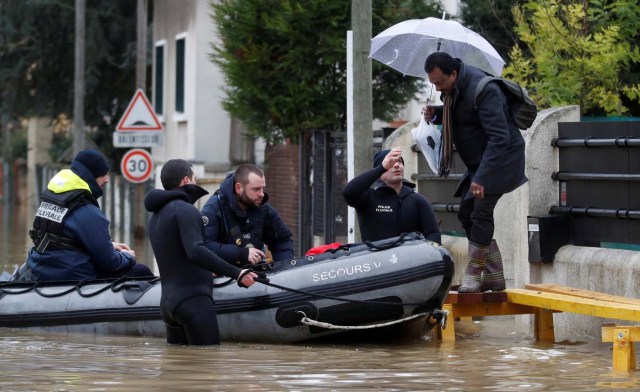 Paris police divers use a small boat to help a resident to leave home as they patrol a flooded street of a residential area in Villeneuve-Saint-Georges, near Paris, France January 25, 2018. REUTERS/Christian Hartmann TPX IMAGES OF THE DAY