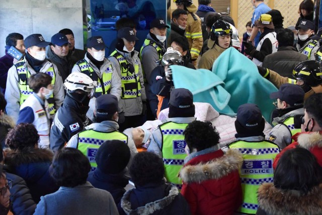 Firefighters rescue a patient from a burnt hospital in Miryang, South Korea, January 26, 2018.   Kim Gu-Yeon/Gyeongn Domin Ilbo/Handout via REUTERS ATTENTION EDITORS - THIS PICTURE WAS PROVIDED BY A THIRD PARTY. SOUTH KOREA OUT.