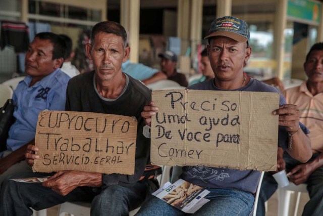 Inmigrantes venezolanos sostienen mensajes en búsqueda de trabajo en la ciudad brasileña de Boa Vista, estado de Roraima, octubre de 2017. Foto cortesía de la Oficina de Naciones Unidas contra la Droga y el Delito (ONUDC)