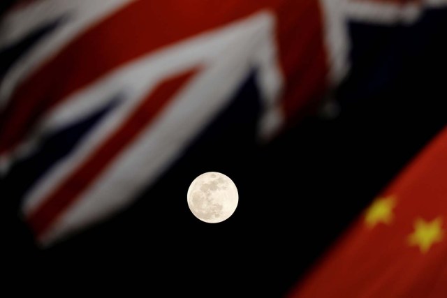 The super blue moon is seen between British and Chinese flags raised at Tiananmen square in Beijing as British Prime Minister Theresa May visit China's capital, January 31, 2018. REUTERS/Damir Sagolj TPX IMAGES OF THE DAY