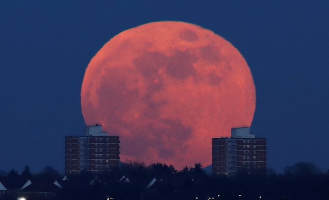 A full moon rises behind blocks of flats in north London, Britain, January 31, 2018. REUTERS/Eddie Keogh